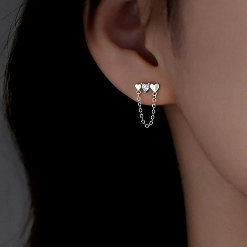 Model showcasing the dangle and style of the Sterling Silver Elegant Heart Chain Tassel Earrings