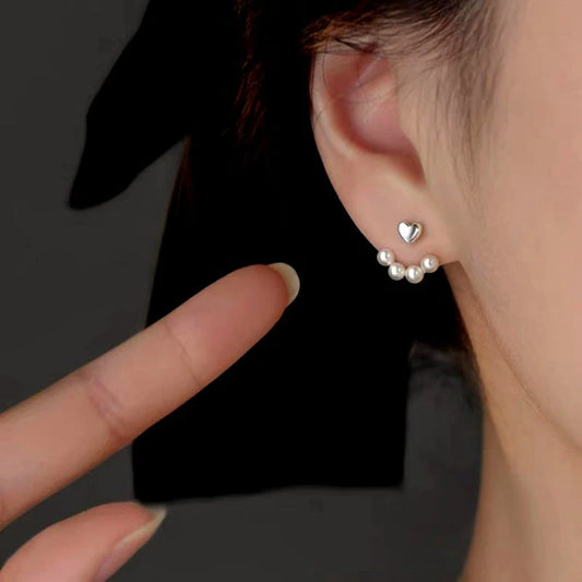 Model showcasing the dangle and style of the Sterling Silver Elegant Heart Pearl Earrings