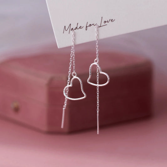 Model showcasing the dangle and style of the Sterling Silver Elegant Hollow Heart Threader Earrings