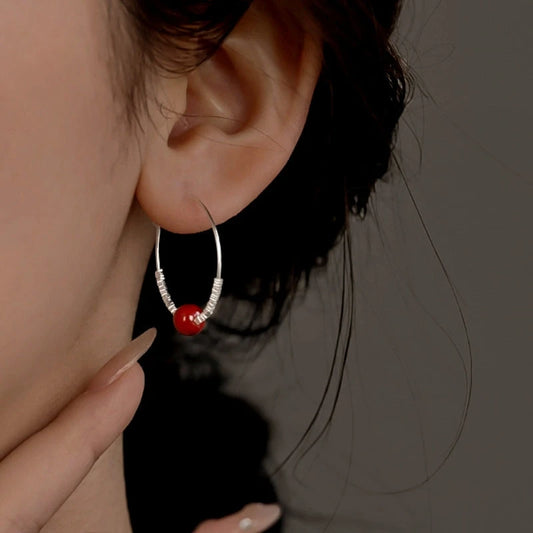 Model showcasing the dangle and style of the Sterling Silver Elegant Pearl Hoop Earrings