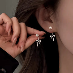 Angled view of the Sterling Silver Elegant Zircon Diamond Bow Pearl Earrings