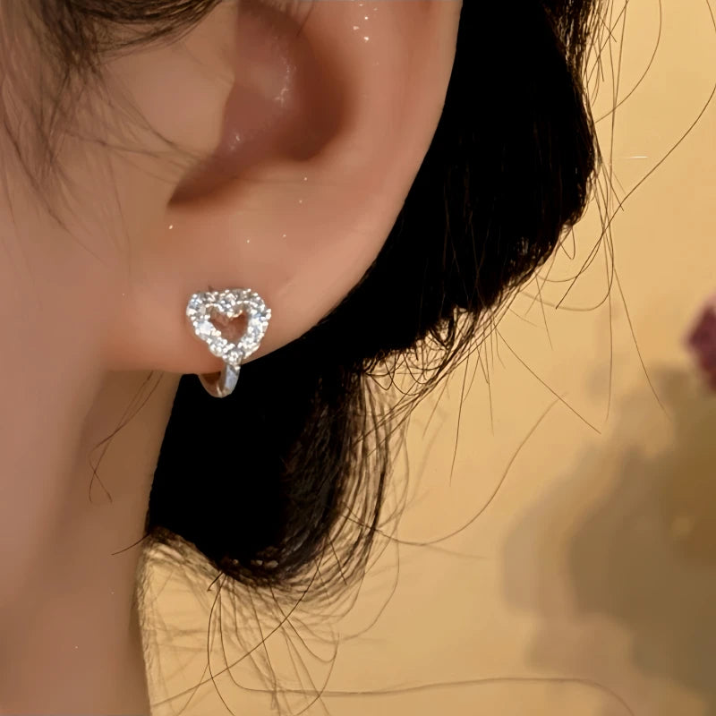 Model showcasing the dangle and style of the Sterling Silver Elegant Zircon Little Heart Hoop Earrings