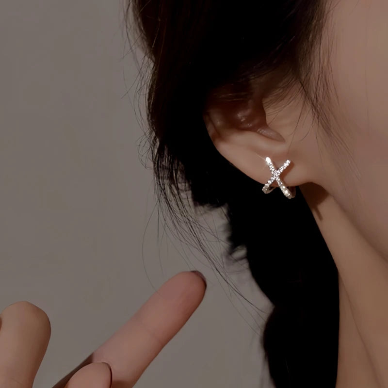 Model showcasing the dangle and style of the Sterling Silver Elegant Zircon X Letter Stud Earrings