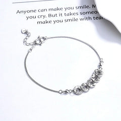 Close-up of the clasp and charm details on the Coin Bracelet