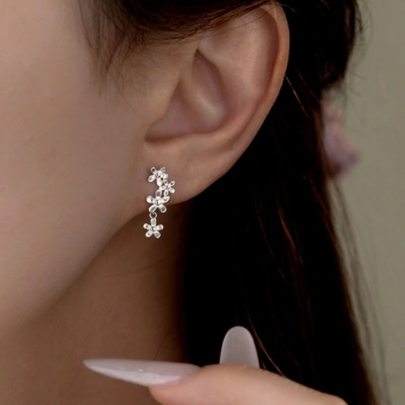 Model showcasing the dangle and style of the Sterling Silver Four-Flower Tassel Screw Earrings