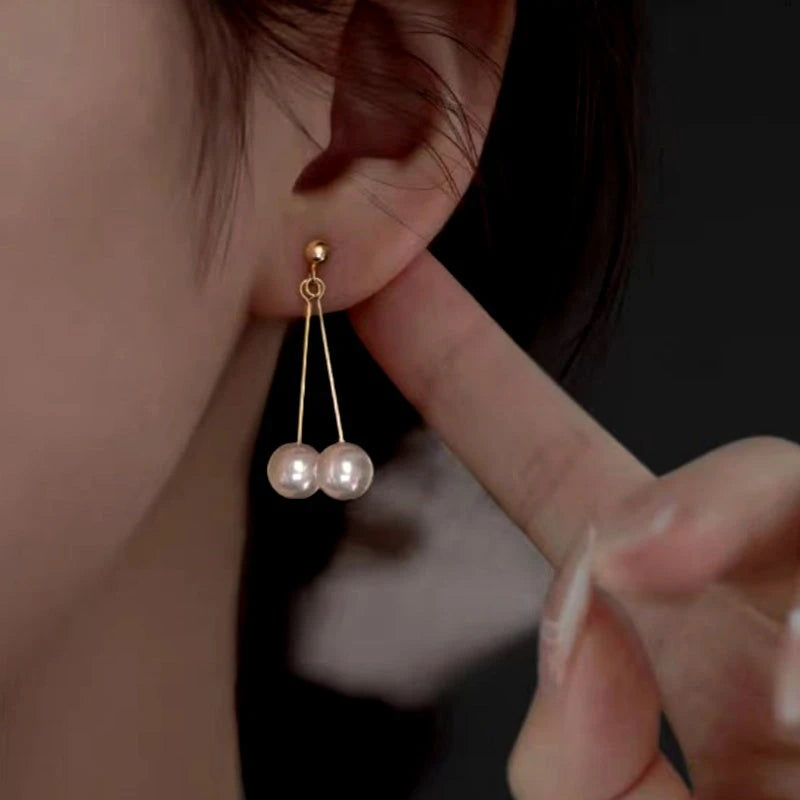 Model showcasing the dangle and style of the Sterling Silver Hanging Double-Pearl Earrings