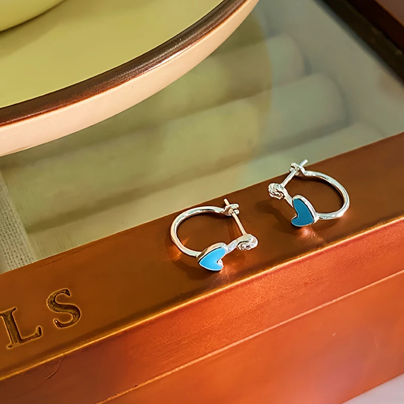 Model showcasing the dangle and style of the Sterling Silver Heart-Design Earrings