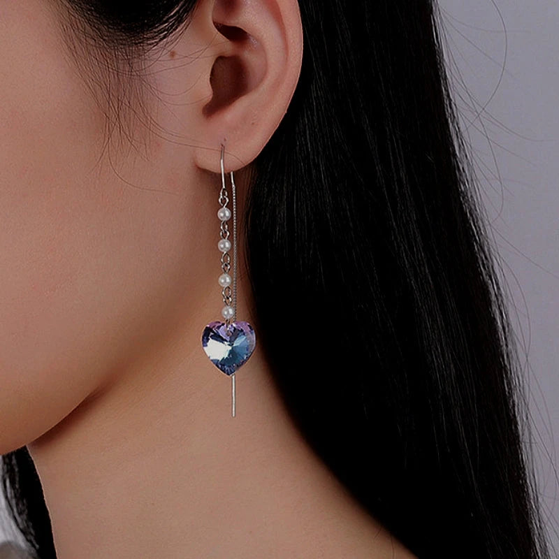 Model showcasing the dangle and style of the Sterling Silver Heart Pearl Tassel Threader Earrings