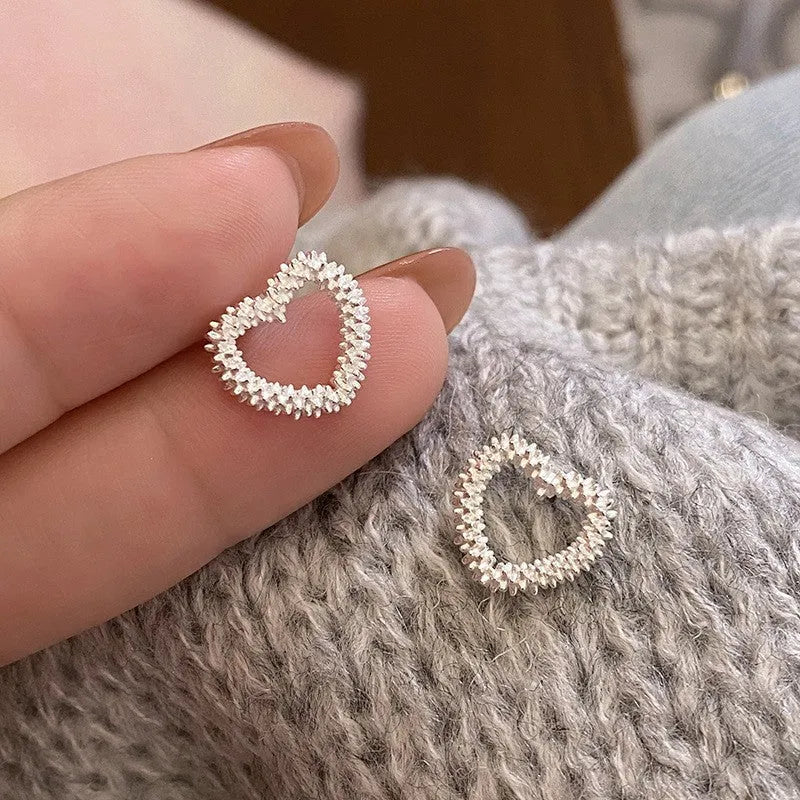 Model showcasing the dangle and style of the Sterling Silver Heart Stud Earrings