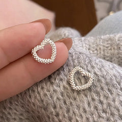 Model showcasing the dangle and style of the Sterling Silver Heart Stud Earrings