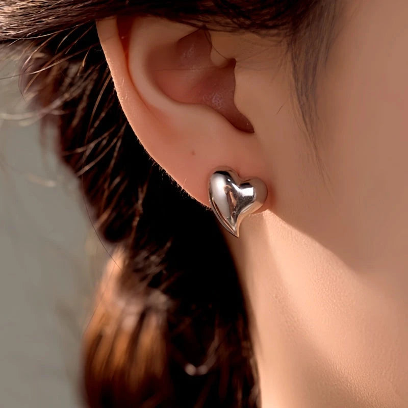 Model showcasing the dangle and style of the Sterling Silver Heart Stud Earrings