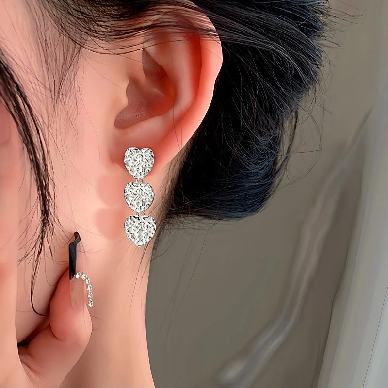 Model showcasing the dangle and style of the Sterling Silver Heart Tassel Earrings