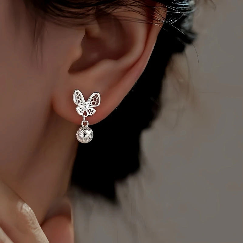 Model showcasing the dangle and style of the Sterling Silver Hollow Butterfly Earrings