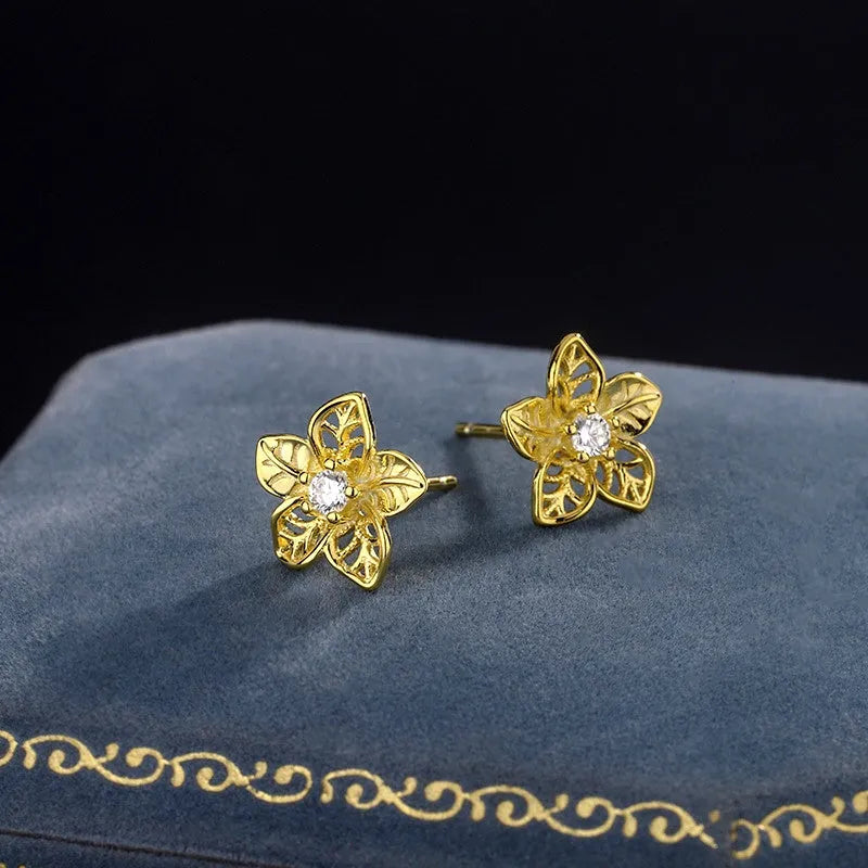 Model showcasing the dangle and style of the Sterling Silver Hollow Flower Stud Earrings