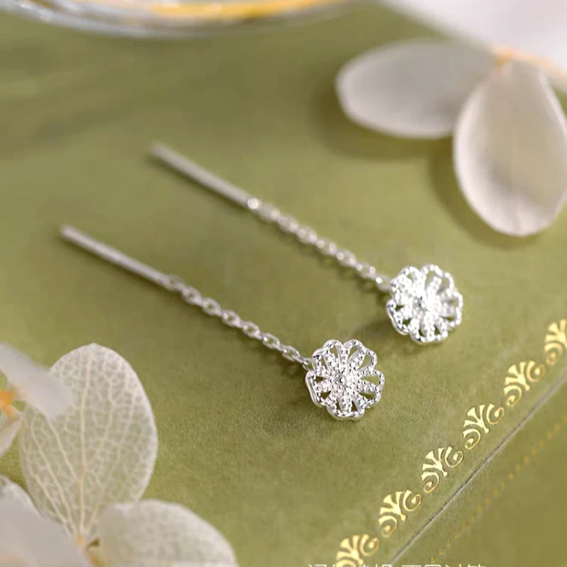 Angled view of the Sterling Silver Hollow Flower Threader Earrings