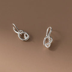 Model showcasing the dangle and style of the Sterling Silver Hollow Heart-Wrapped Ear Hook Earrings