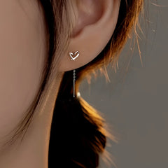 Model showcasing the dangle and style of the Sterling Silver Hollow Heart Threader Earrings