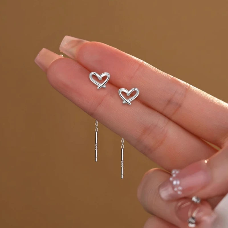 Angled view of the Sterling Silver Hollow Heart Threader Earrings