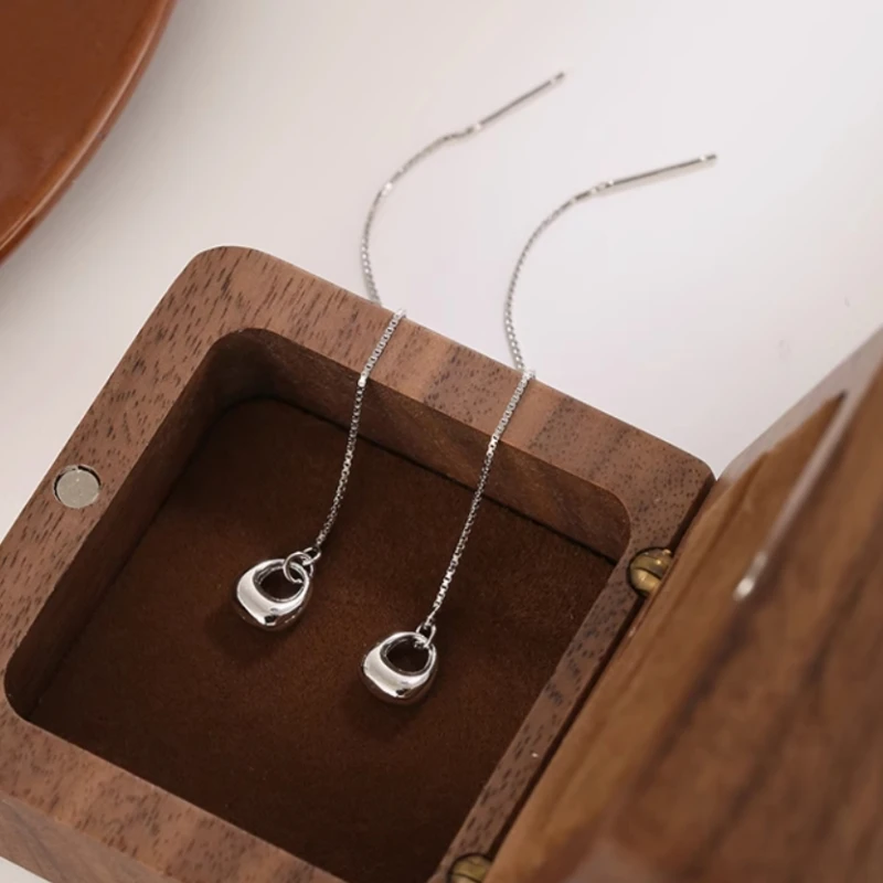 Angled view of the Sterling Silver Hollow Oval Threader Earrings