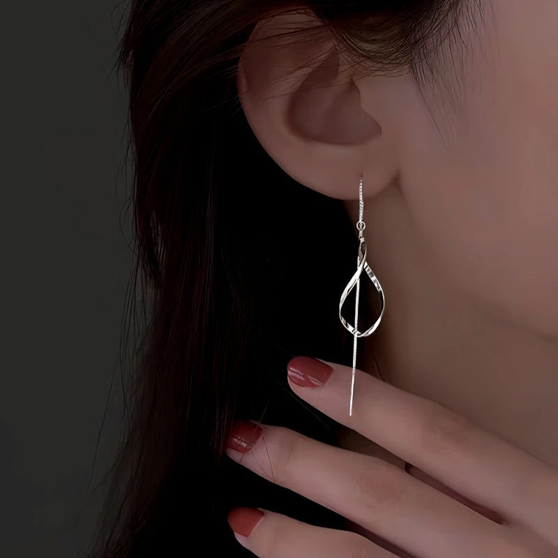 Model showcasing the dangle and style of the Sterling Silver Hollow Wavy Leaf Threader Earrings