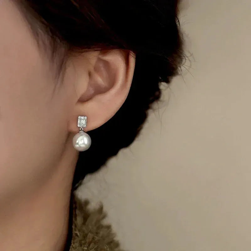 Model showcasing the dangle and style of the Sterling Silver Luxury Zircon Diamond Pearl Earrings