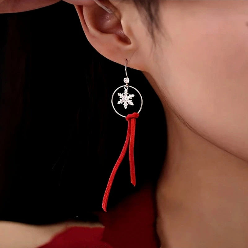 Model showcasing the dangle and style of the Sterling Silver Moose Snowflake Circle Red Velvet Tassel Earrings