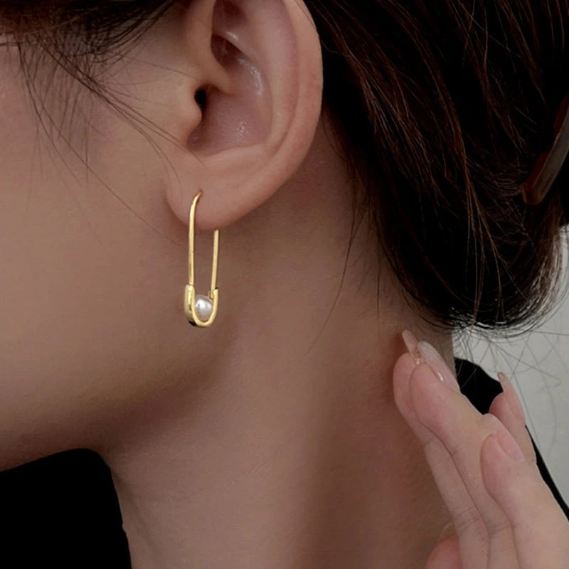 Model showcasing the dangle and style of the Sterling Silver Paper Clip Imitation Pearl Earrings