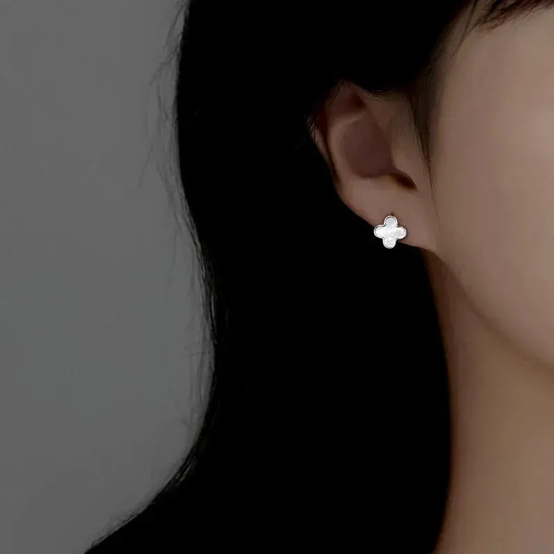Model showcasing the dangle and style of the Sterling Silver Pearl Four-Leaf Clover Earrings