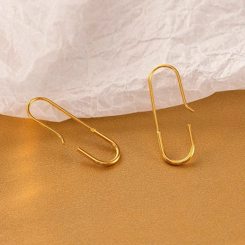 Pair of gold earring hooks for jewelry making on warm textured background