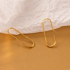 Pair of gold earring hooks for jewelry making on warm textured background