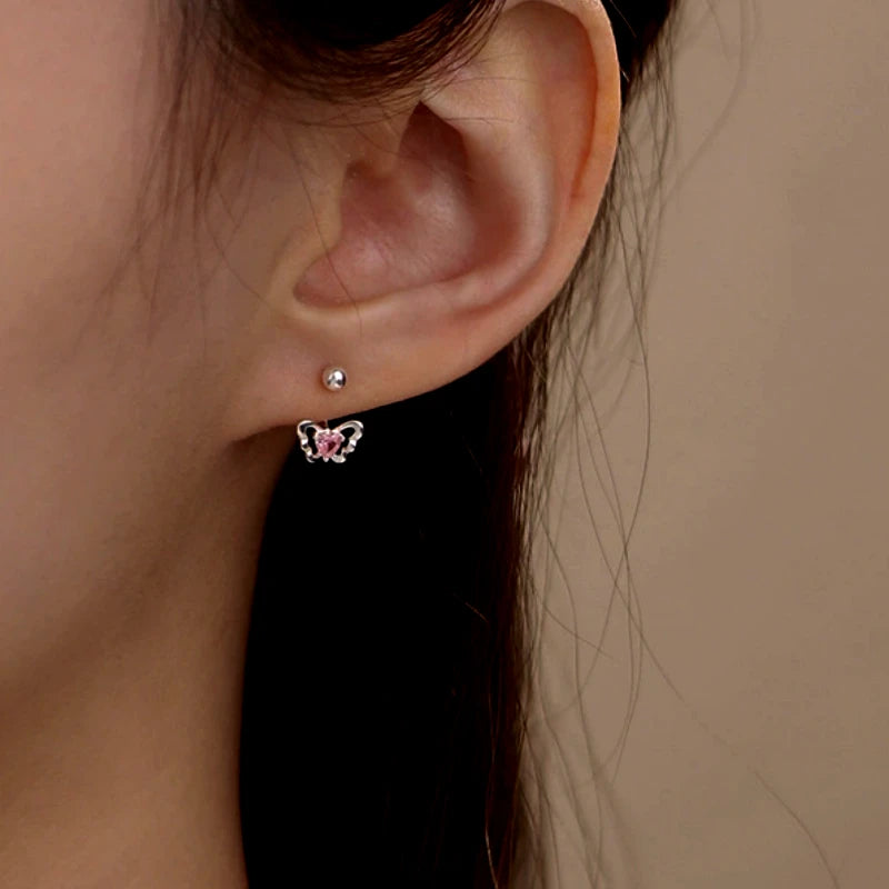 Model showcasing the dangle and style of the Sterling Silver Pink Diamond Heart Butterfly Screw Earrings