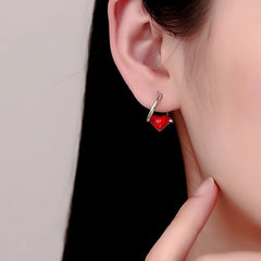 Model showcasing the dangle and style of the Sterling Silver Red Heart Earrings