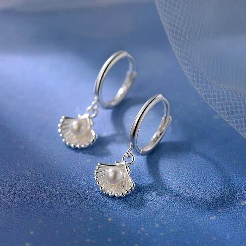 Model showcasing the dangle and style of the Sterling Silver Shell Pearl Earrings