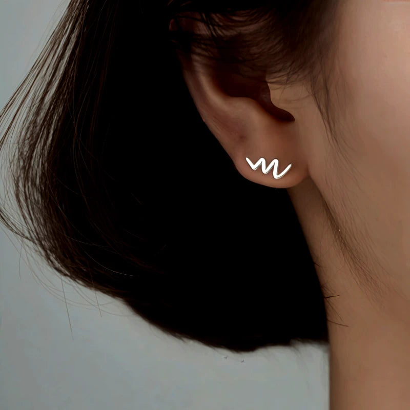 Model showcasing the dangle and style of the Sterling Silver Simple Glossy Wave Stud Earrings