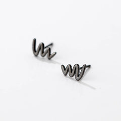 Angled view of the Sterling Silver Simple Glossy Wave Stud Earrings