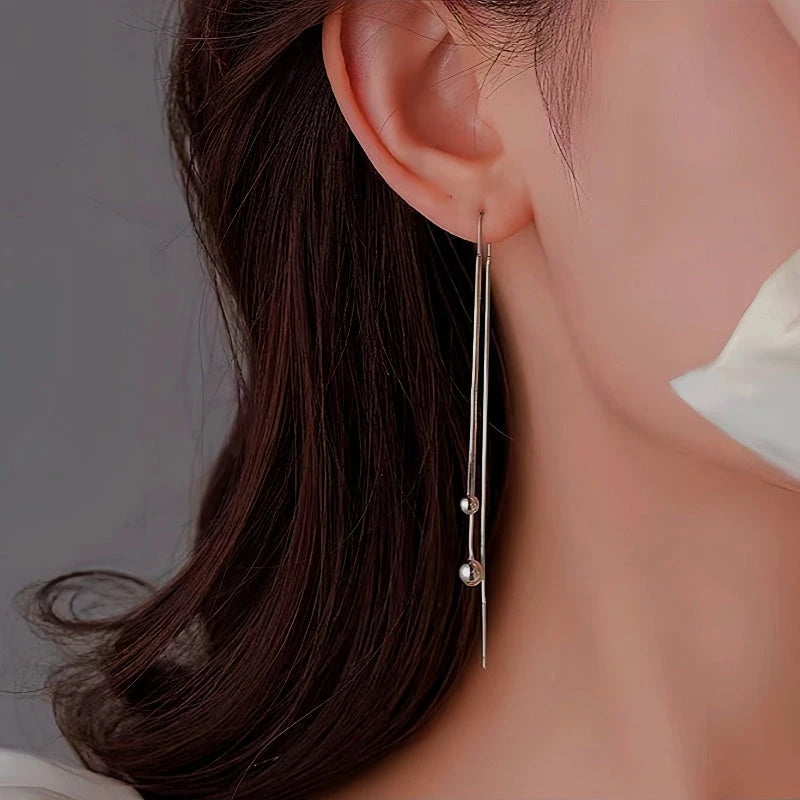 Model showcasing the dangle and style of the Sterling Silver Small Bean Tassel Threader Earrings