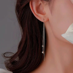 Model showcasing the dangle and style of the Sterling Silver Small Bean Tassel Threader Earrings