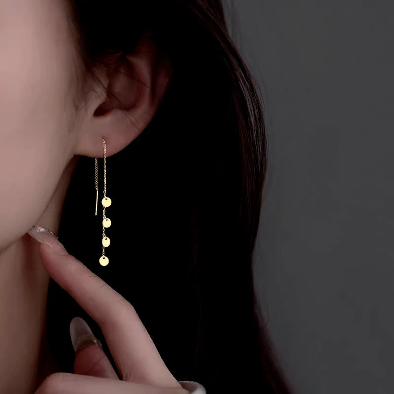 Model showcasing the dangle and style of the Sterling Silver Small Disc Tassel Threader Earrings