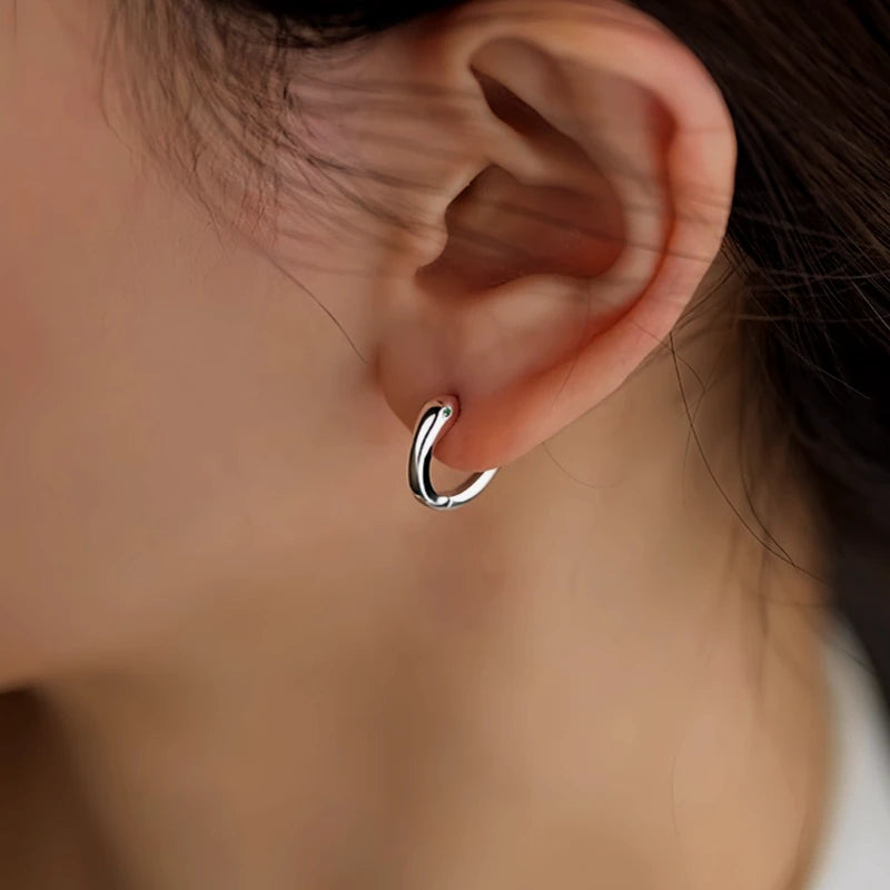 Model showcasing the dangle and style of the Sterling Silver Snake Hoop Earrings