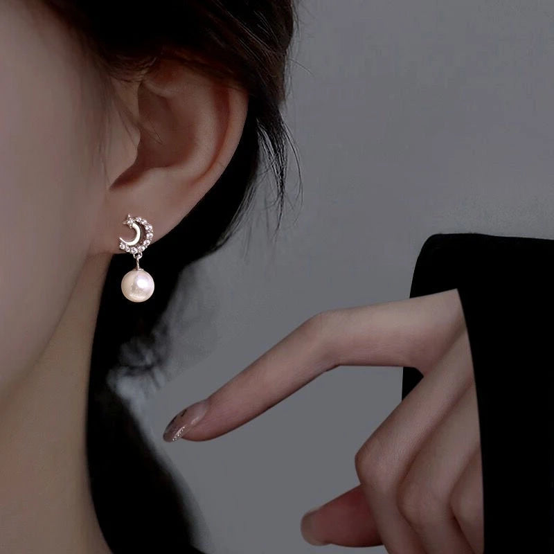 Model showcasing the dangle and style of the Sterling Silver Star Moon Pearl Earrings