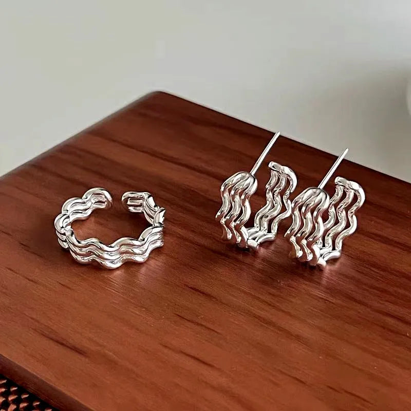 Angled view of the Sterling Silver Three-Layer Wave Texture Earrings