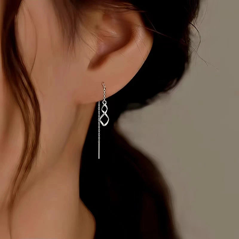 Model showcasing the dangle and style of the Sterling Silver Wavy Eight-Shaped Threader Earrings