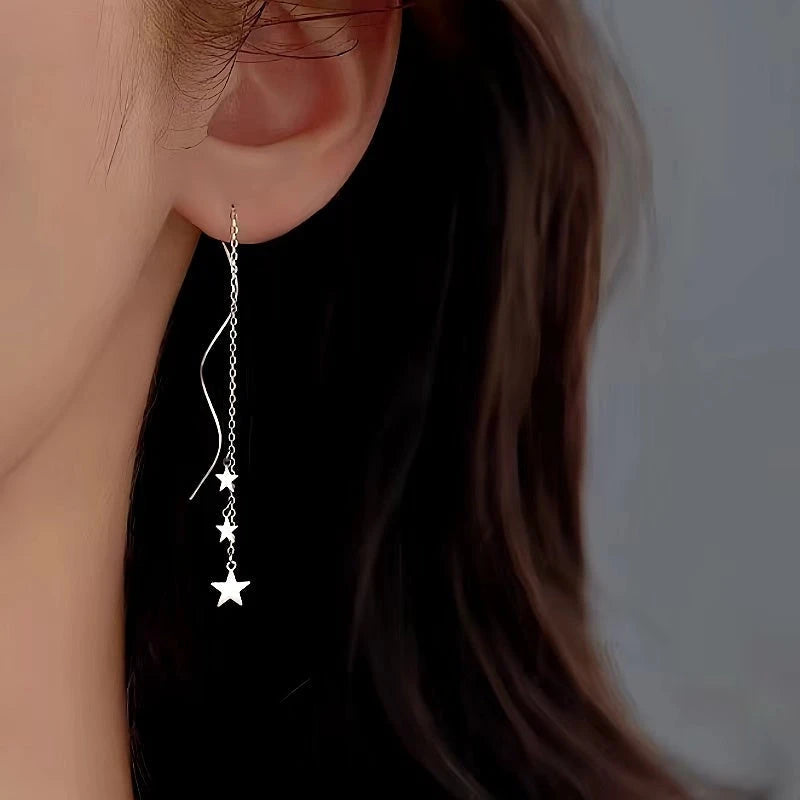 Model showcasing the dangle and style of the Sterling Silver Wavy Large And Small Star Threader Earrings