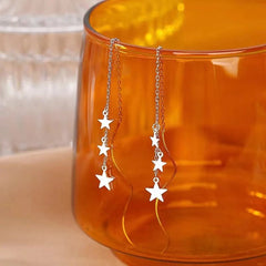 Angled view of the Sterling Silver Wavy Large And Small Star Threader Earrings