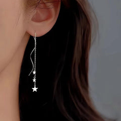 Model showcasing the dangle and style of the Sterling Silver Wavy Large And Small Star Threader Earrings