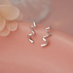 Model showcasing the dangle and style of the Sterling Silver Wavy Ribbon Earrings