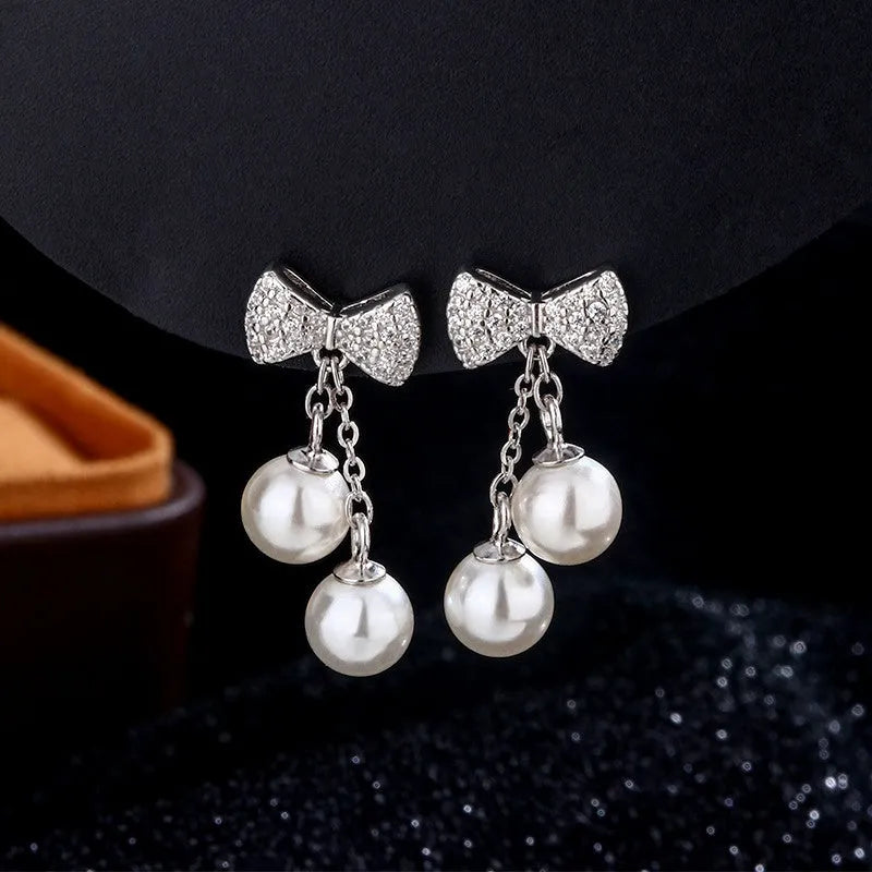 Close-up detail of the sparkling zircons and plating on the Bow Pearl Tassel Earrings