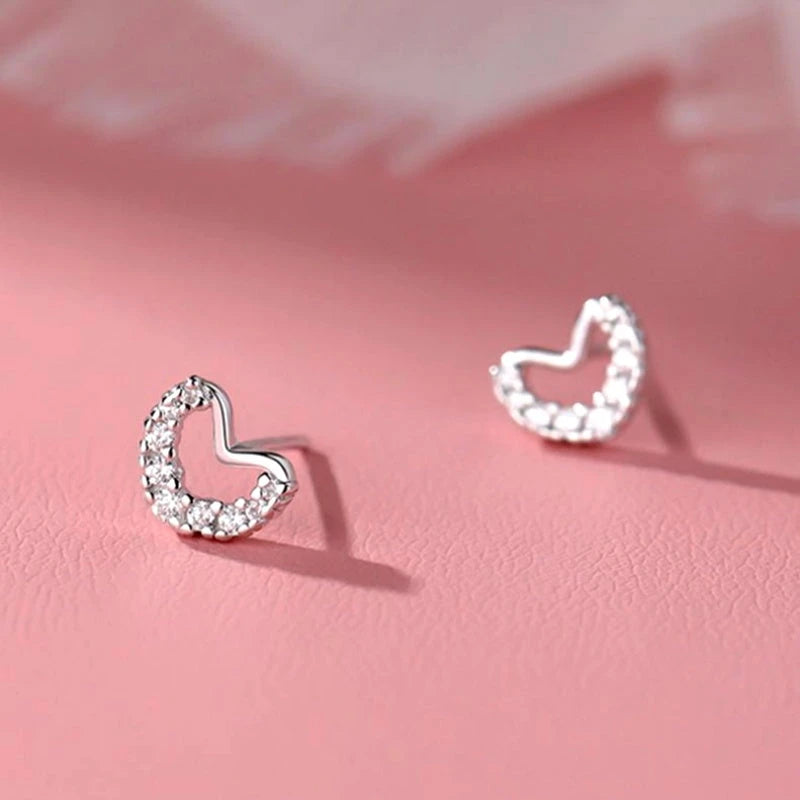 Model showcasing the dangle and style of the Sterling Silver Zircon Diamond Heart Stud Earrings