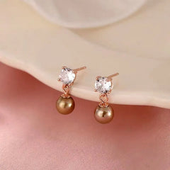 Model showcasing the dangle and style of the Sterling Silver Zircon Diamond Pearl Earrings