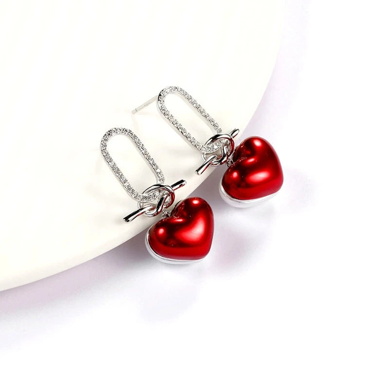 Model showcasing the dangle and style of the Sterling Silver Zircon Heart Earrings